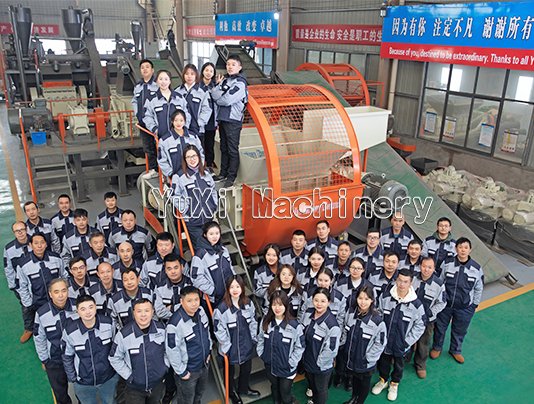 Employees of YuXi Machinery in front of a large tire shredder