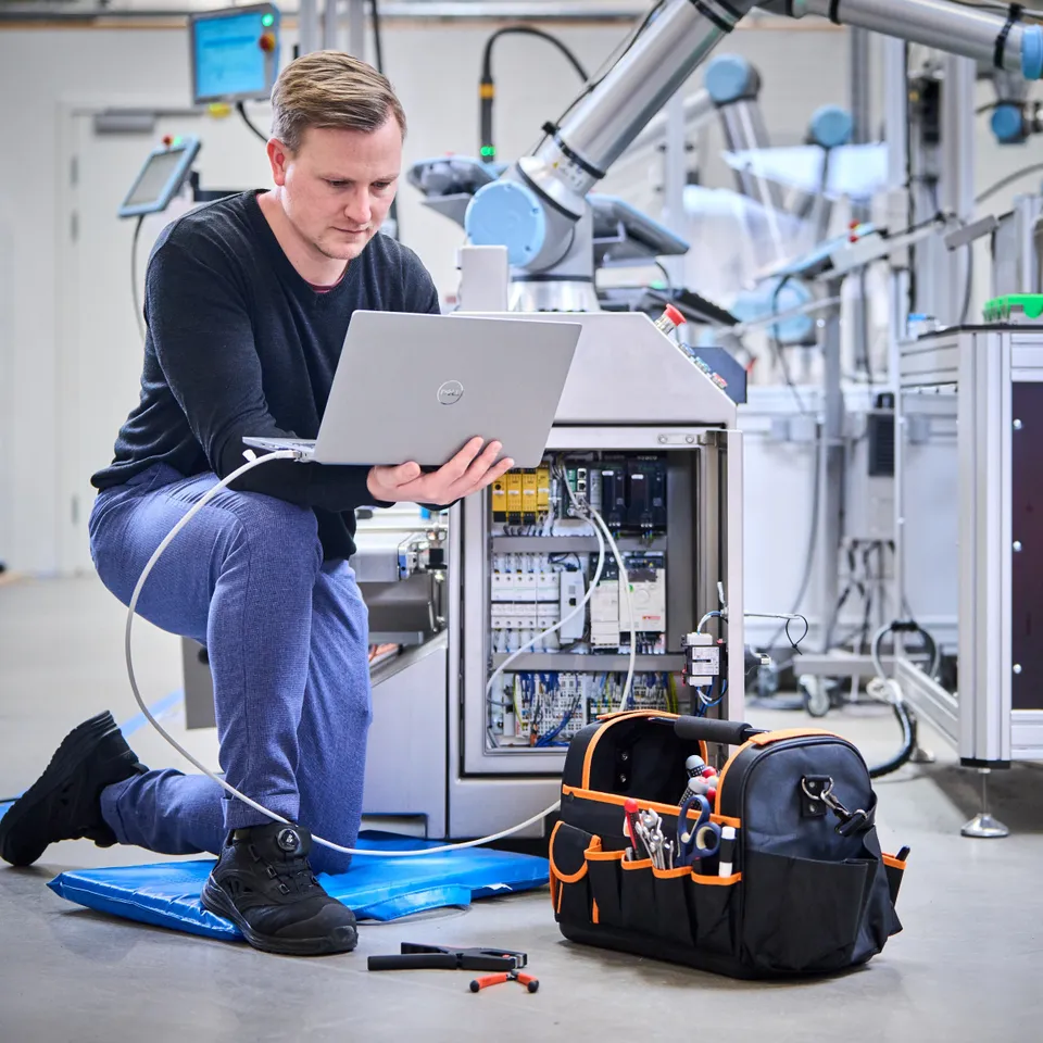 Technician servicing a robotic arm